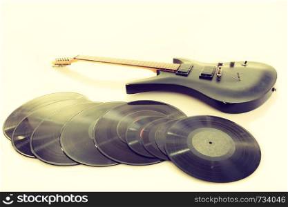 Equipment of musician. Electric electro black guitar string intrument and vinyl records lying ready to use.. Musical equipment lying ready to use.