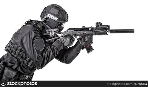 Equipped army soldier, special forces elite member, commando fighter, police SWAT shooter protected with in body armor and helmet, aiming with assault rifle, isolated on white background. Modern army soldier, police SWAT member on white