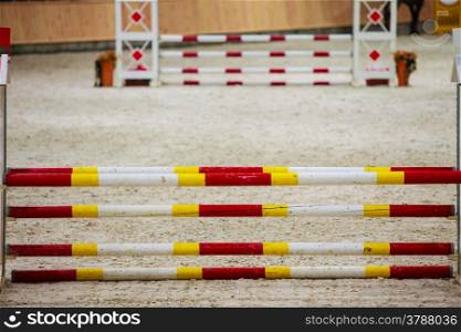 Equitation. Yellow red white obstacle for jumping horses. Riding competition. Real.
