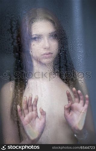 ER20180424-Young_Woman_Wearing_Lingerie-00004.jpg. Sad young woman looking through the window on a rainy day