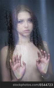 ER20180424-Young_Woman_Wearing_Lingerie-00004.jpg. Sad young woman looking through the window on a rainy day