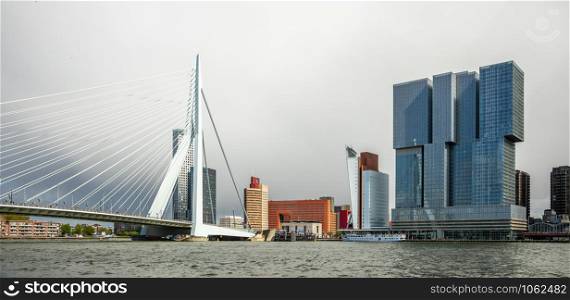 Erasmus Bridge and downtown skyscrapers at the embankment of Maas river, Rotterdam. The Netherlands