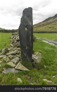 Erected vertically, slate sleeper, wityh two holes drilled. The sleeper is beside the course of the Croesor Tramway, from which it was taken.