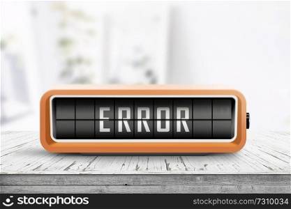 Error message on a wooden desk with a retro alarm clock on a bright day