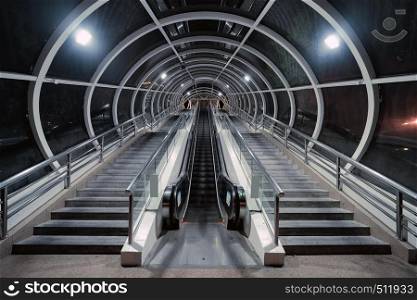 Escalator and tunnel in a train station to transfer in Shanghai City, China at night. Architectural structure of roof. Interior design background