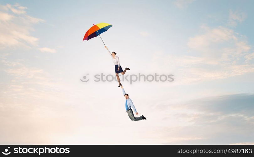 Escape from office. Business people flying in the sky on umbrella