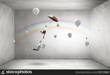 Escape from office. Businessman and businesswoman flying on colorful umbrella