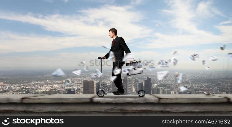 Escape from office. Young cheerful businessman riding scooter against city background