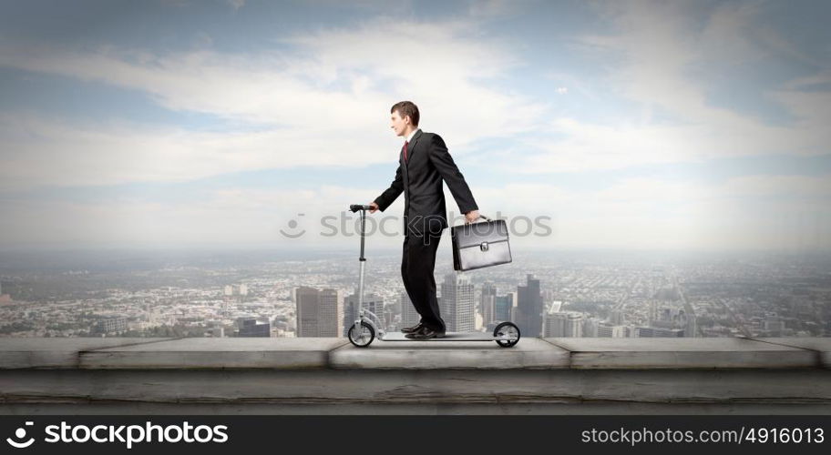 Escape from office. Young cheerful businessman riding scooter against city background