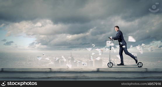 Escape from office. Young cheerful businessman riding scooter against city background