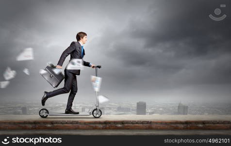 Escape from office. Young cheerful businessman riding scooter against city background