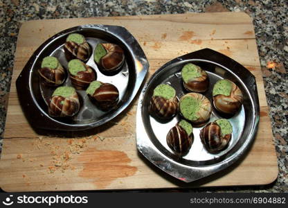 Escargots de Bourgogne on a metal plate ready to put in the oven