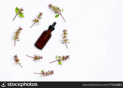 Esential oil with sweet basil flower on white background.