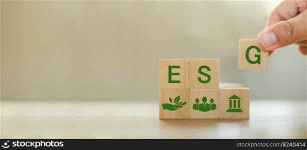 ESG Concepts on Environment, Society and Governance Sustainable Development Organization Hand holding ESG wooden block with ESG icon pictogram on copy space background.