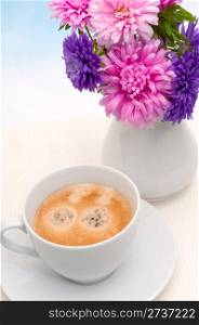 Espresso Coffee in White Cup and Dahlia Flowers in Vase on Table