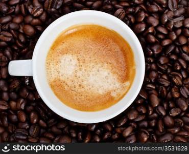 espresso cup in coffee beans, top view