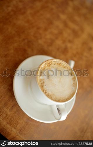 Espresso in a classic cup on a wooden table top view