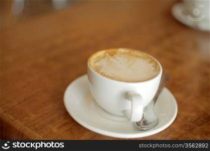 Espresso in a classic cup on a wooden table top view