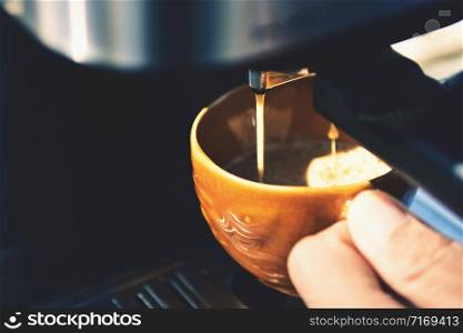 Espresso pouring from coffee machine. Barista Cafe Making Coffee Preparation Service Concept, Close-up