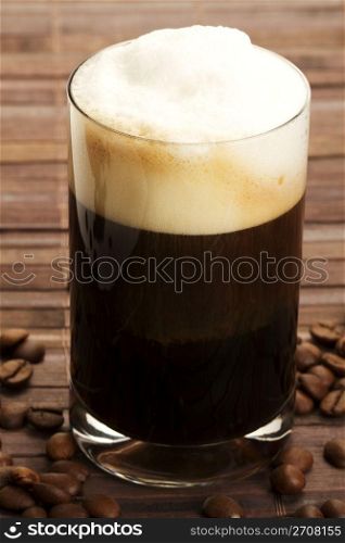 espresso with milk froth and coffee beans. espresso with milk froth and coffee beans on wooden background