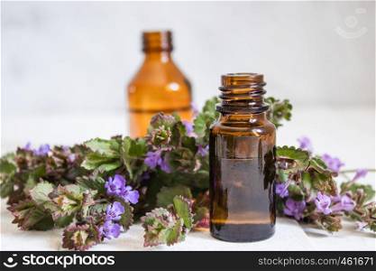 Essential aromatic oil with flowers on wooden background. Selective focus. Natural essential oil.. Essential aromatic oil with flowers on wooden background. Selective focus.