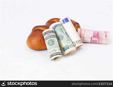 Essential financial concept of a global marketplace is portrayed through four national currencies -- dollar, yen, euro, and yuan -- in front of a common loaf.
