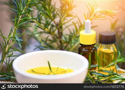 Essential oil bottle natural spa ingredients rosemary oil for aromatherapy and rosemary leaf plant on background / Organic cosmetics with extracts of herbs