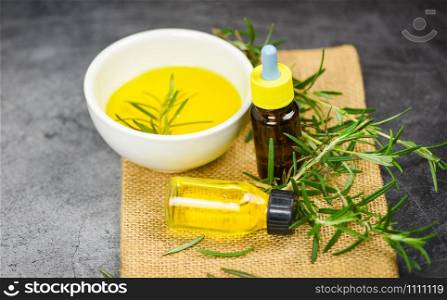 Essential oil bottle natural spa ingredients rosemary oil for aromatherapy and rosemary leaf plant on sack background / Organic cosmetics with extracts of herbs