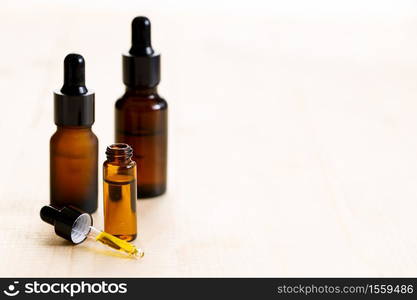 Essential oil in amber glass bottle with fresh green mint leaves on wooden background, with copy space.