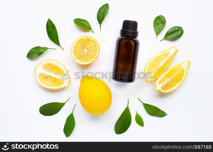 Essential oil with Fresh lemon and green leaves on white background.