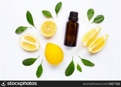 Essential oil with Fresh lemon and green leaves on white background.