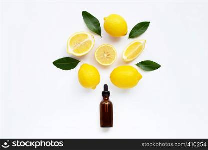 Essential oil with lemon and green leaves isolated on white background.