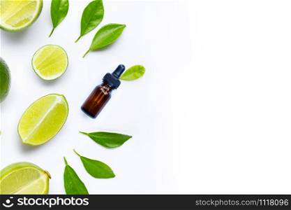 Essential oil with limes and leaves isolated on white background. Copy space