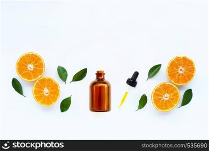 Essential oil with orange fruits with leaves on white background. Top view