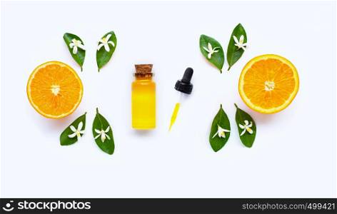 Essential oil with oranges on white background.