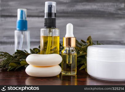 Essential oils and medicinal herbs. Soap and cream in the foreground.