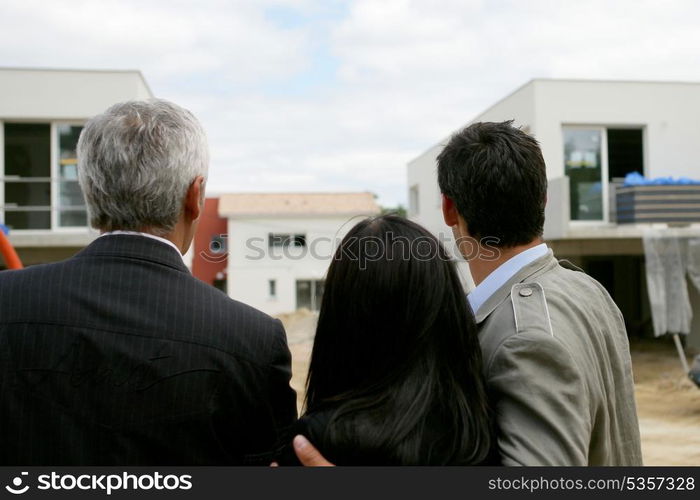 Estate agent showing a couple a housing development