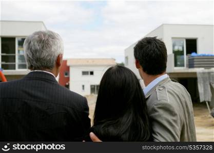 Estate agent showing a couple a housing development