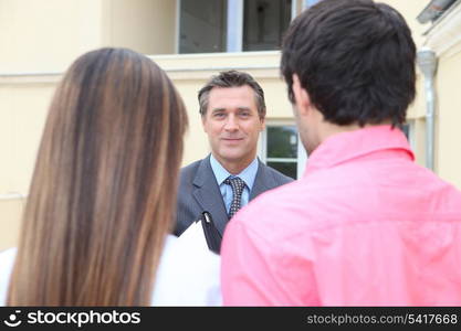 Estate-agent welcoming couple