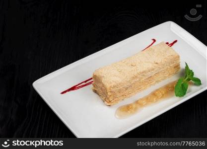 Esterhazy traditional cake with mint on black wooden background. Esterhazy Torte on plate