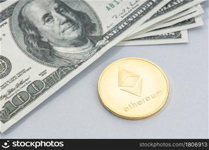 Ethereum coin and a pile of US dollar banknotes. Blockchain money versus fiat money concept