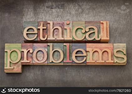 ethical problems - text in vintage letterpress wood type on a grunge metal background
