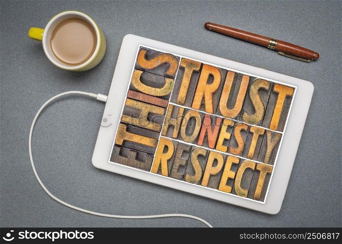 ethics, trust, honesty, respect - word abstract in vintage letterpress wood type on a digital tablet, flat lay  with a cup of coffee, business and core values concept