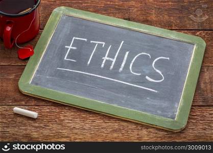 ethics word - white chalk handwriting on a slate blackboard with a cup of tea