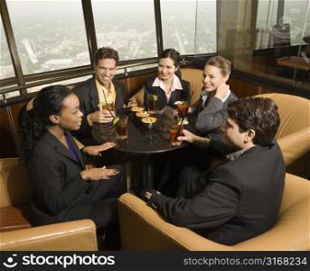 Ethnically diverse businesspeople sitting at table in restaurant talking.