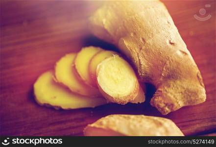 ethno science, culinary, diet, eco food and objects concept - close up of ginger root on wooden table. close up of ginger root on wooden table