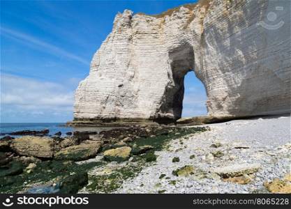 Etretat Aval cliff, rocks and natural arch landmark and blue ocean. France, Europe