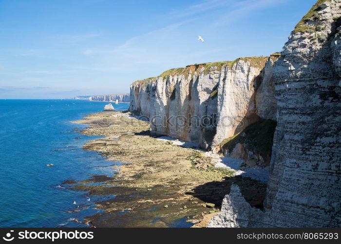 Etretat Aval cliff, rocks and natural arch landmark and blue ocean. France, Europe