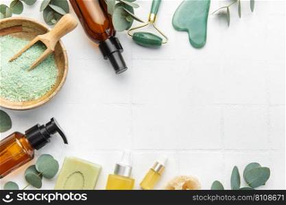 Eucalyptus, towel, massage salt, aroma oil,  spa objects on white tile background. Top view. Skin care, body treatment concept. 
