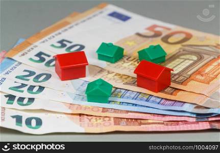 Euro banknotes and small plastic house as concept for the price of housing